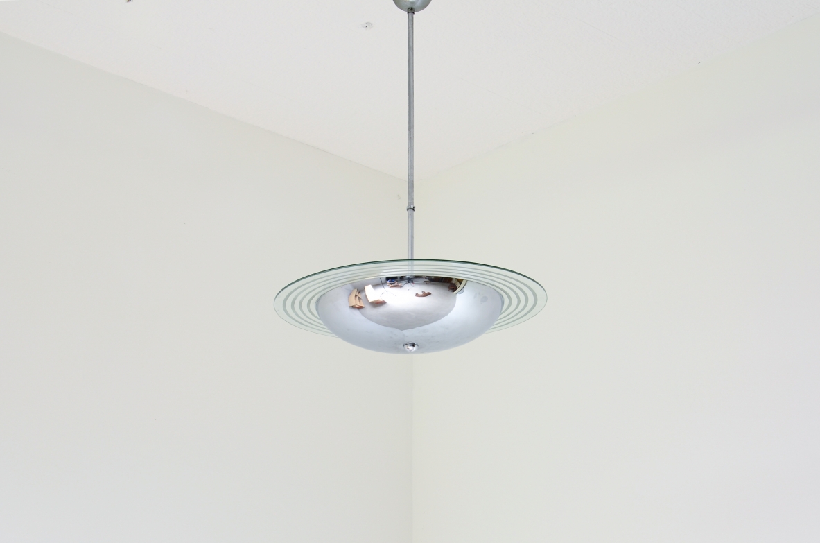 Lampadario in metallo cromato con disco in cristallo molato e inciso.  Manifattura italiana 1960ca.