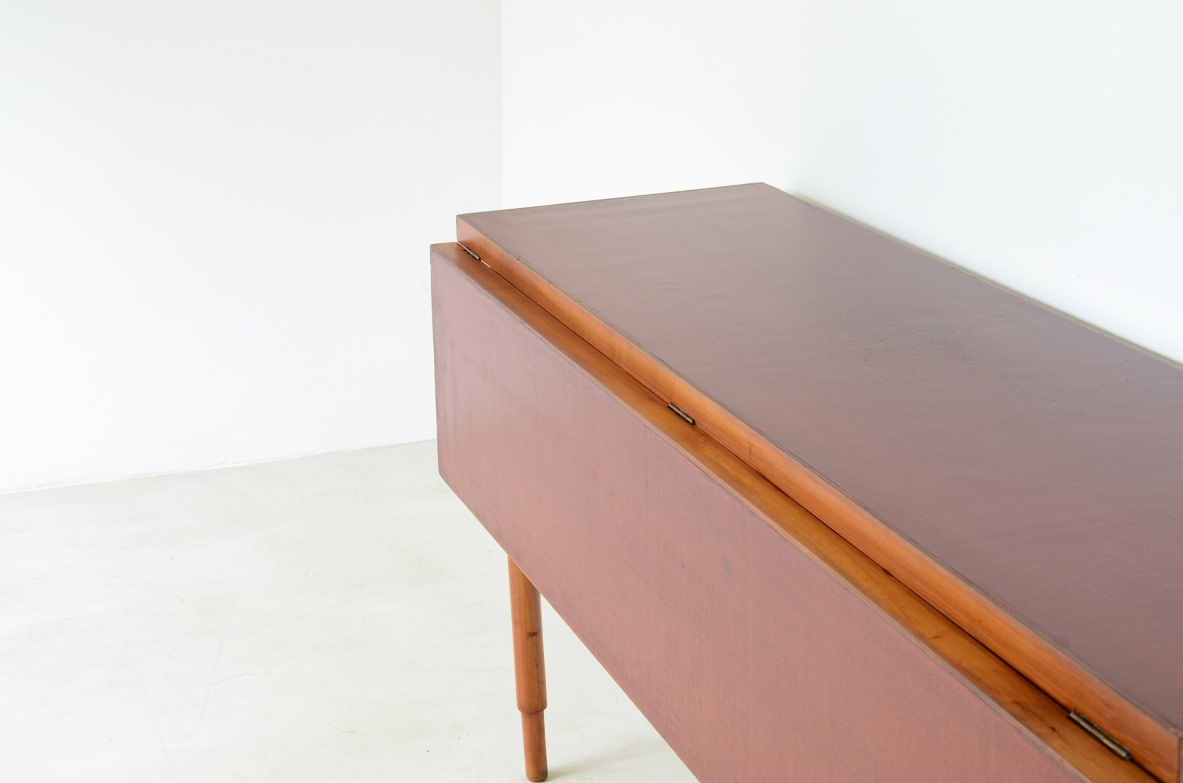 Tavolo console in noce con piano laccato rosso.