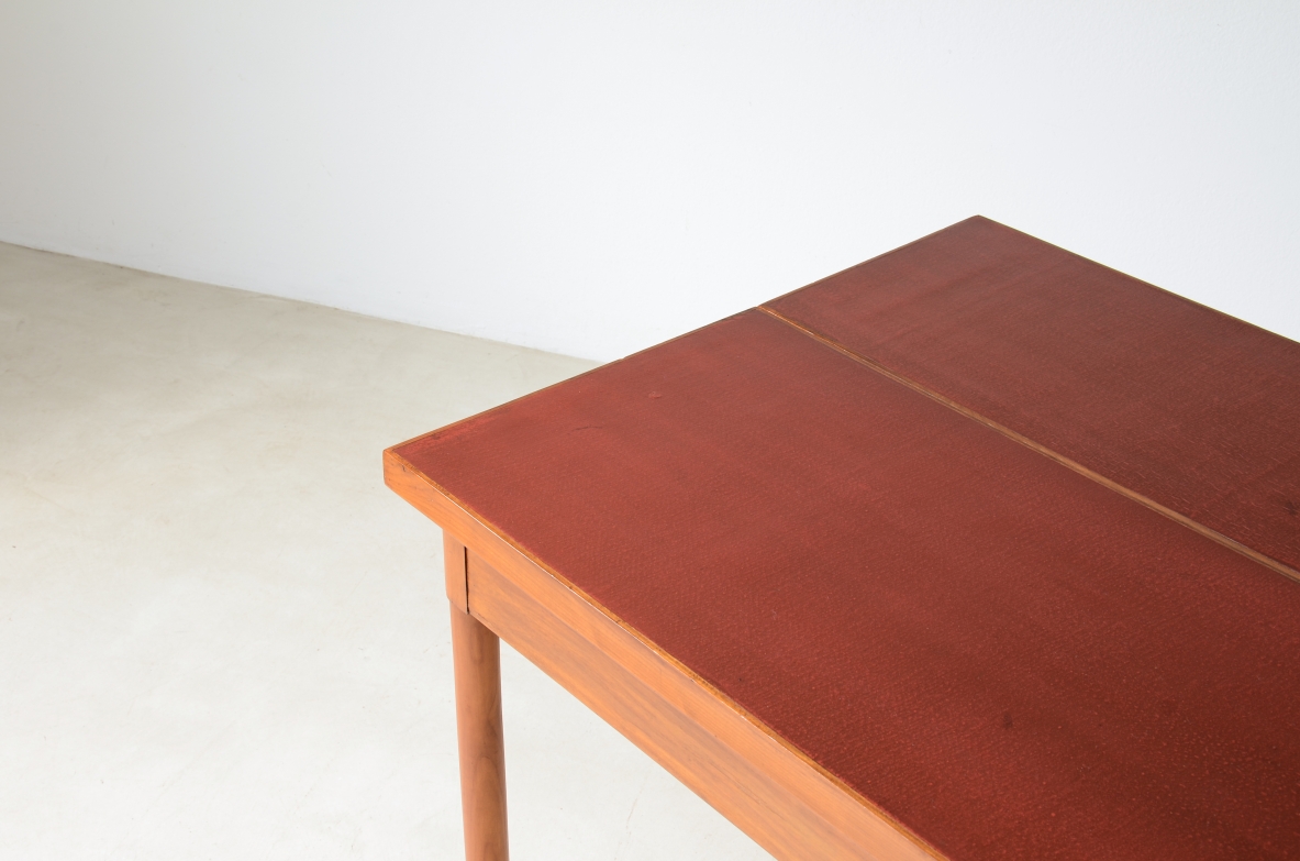Tavolo console in noce con piano laccato rosso.
