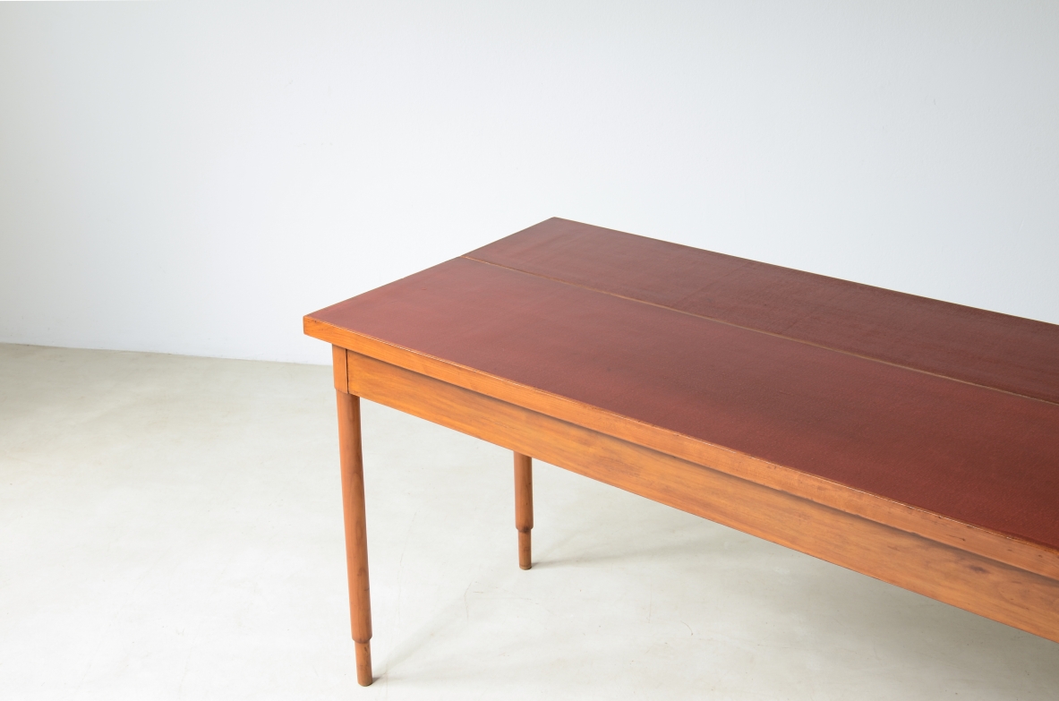 Tavolo console in noce con piano laccato rosso.