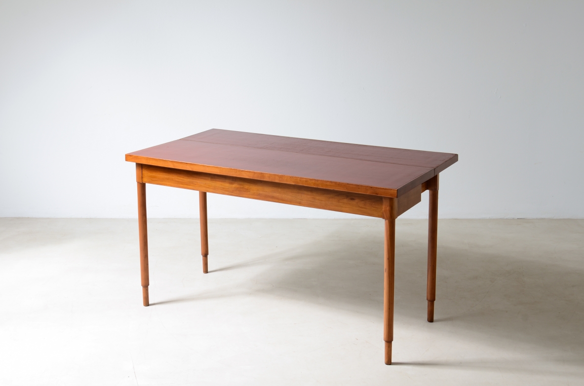 Tavolo console in noce con piano laccato rosso.