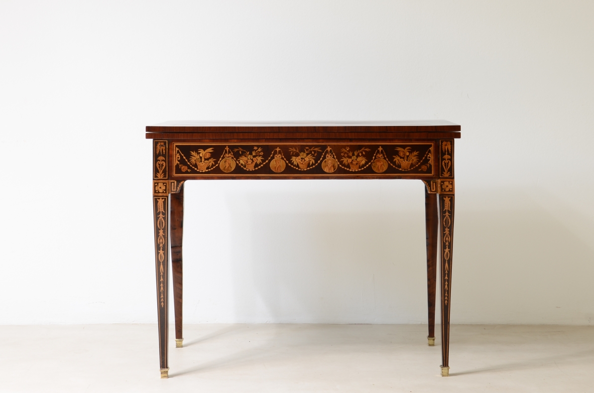 Elegante tavolino da gioco con disegni a intarsio. Interno rivestito in panno.  Manifattura lombarda, epoca Luigi XVI. 1780ca.