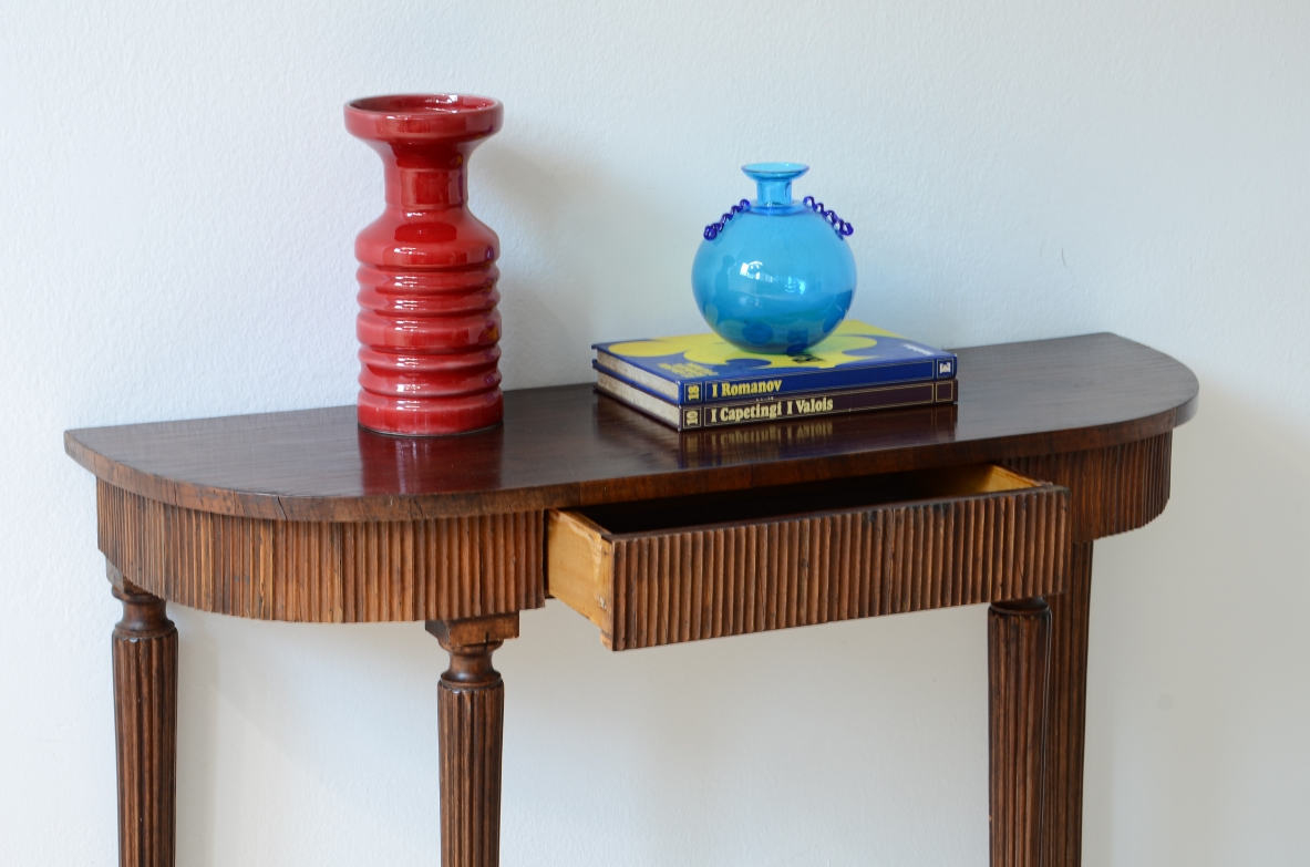 Piccola console in noce con piano curvato e fascia in legno cannettato.Manifattura italiana 1940ca.
