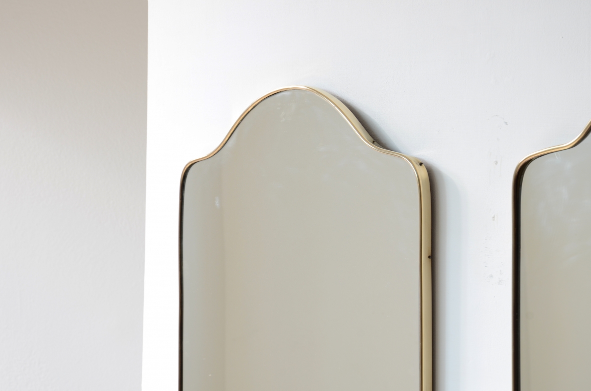 Coppia di specchiere con cornice in ottone sagomato.  Manifattura italiana anni 50ca.
