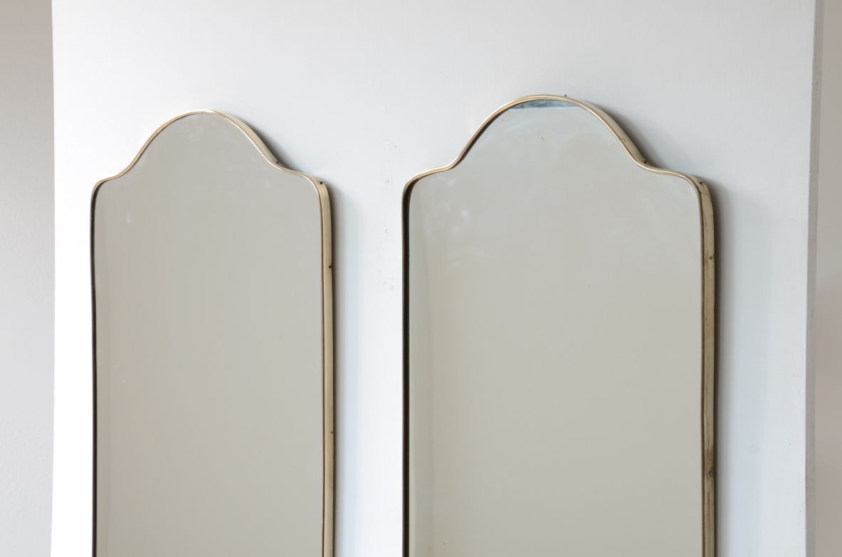 Coppia di specchiere con cornice in ottone sagomato.  Manifattura italiana anni 50ca.