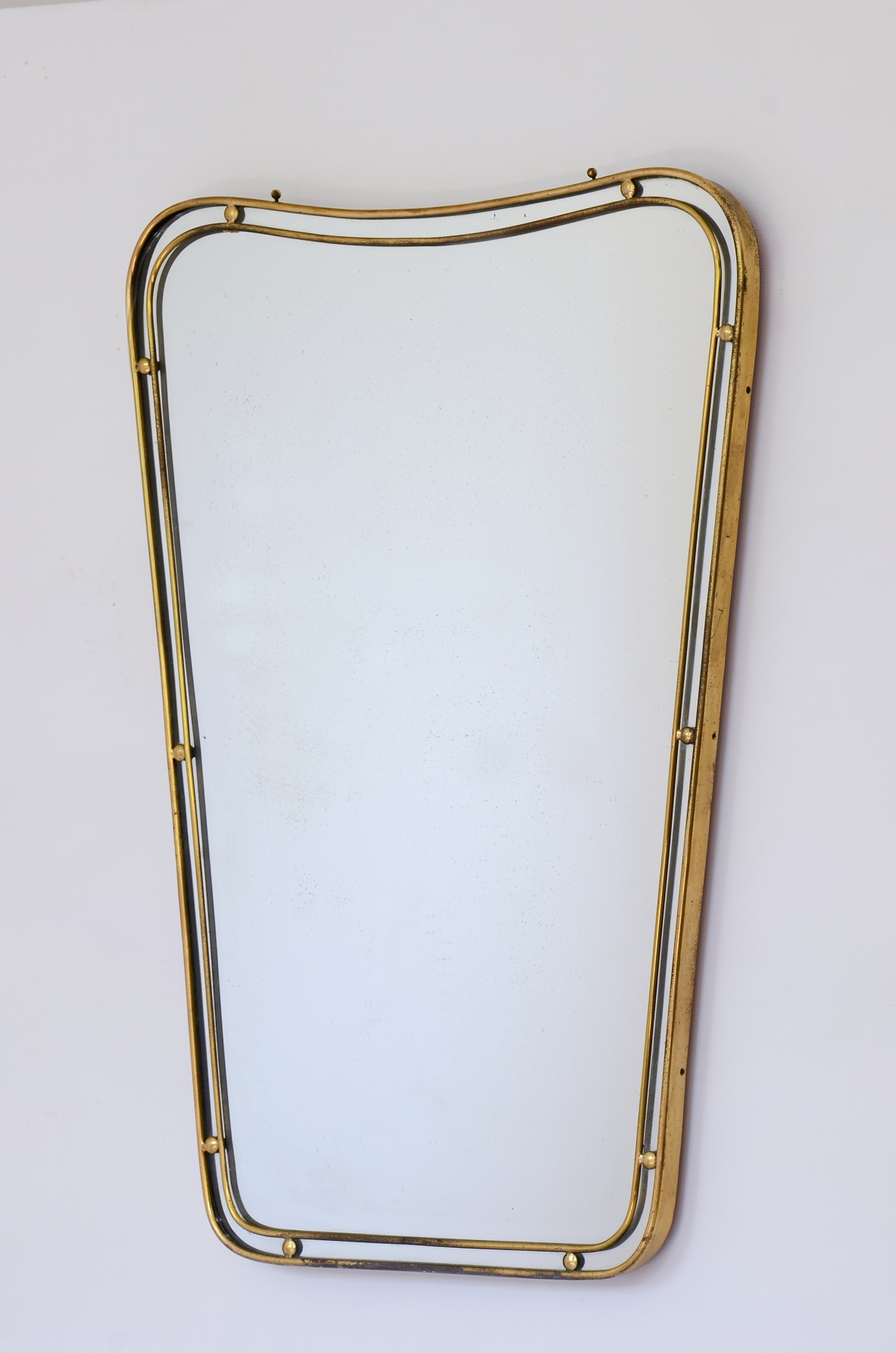 Mirror with double profile shaped brass frame with ball spacers.  Italian manufacture ca. 1950.