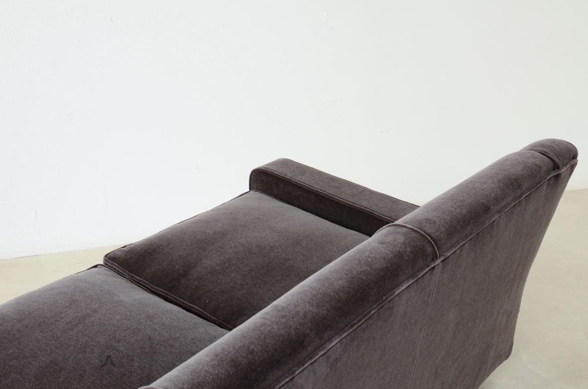 Three-seater sofa with wooden base and padded velvet upholstery.