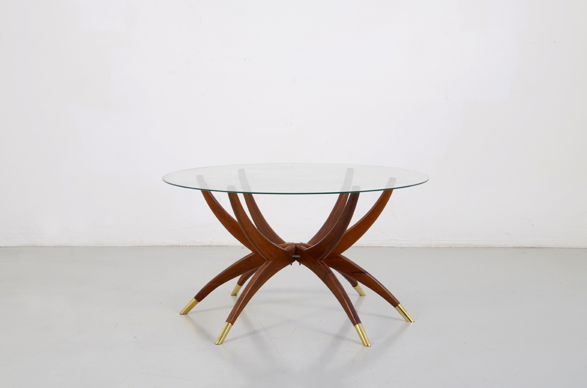 Elegante tavolino in mogano a sei razze in mogano con sottili puntali in ottone e piano in cristallo. Design Carlo de Carli, 1950ca.