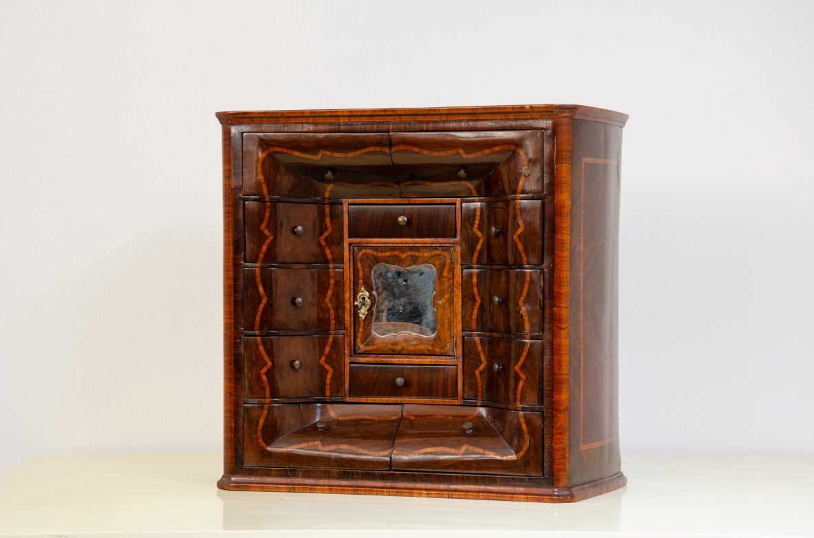 Ebanisteria genovese, 1750ca, monetiere in legno di viola filettato in legno di rosa con fronte mosso, edicola centrale con sportello sagomato e specchio centrale