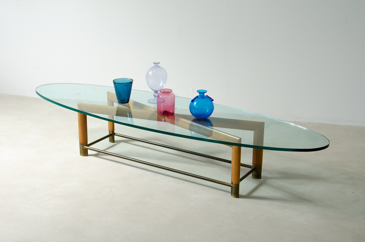 Tavolino ovale con struttura in legno, piedini in ottone e piano in cristallo molato. Manifattura italiana, 1950ca.
