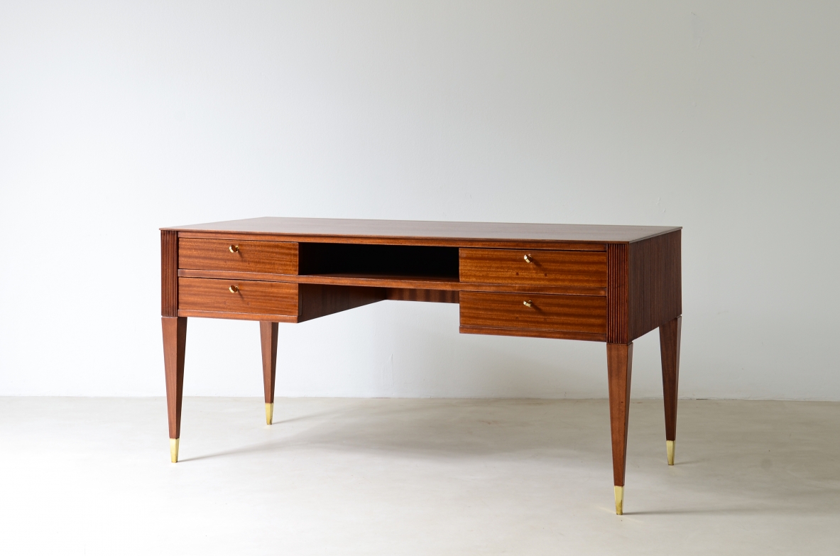 Scrivania in mogano a 4 cassetti con fronte e lati in legno grissinato,      gambe tronco piramidali con puntali in ottone.  Manifattura italiana anni 50'.