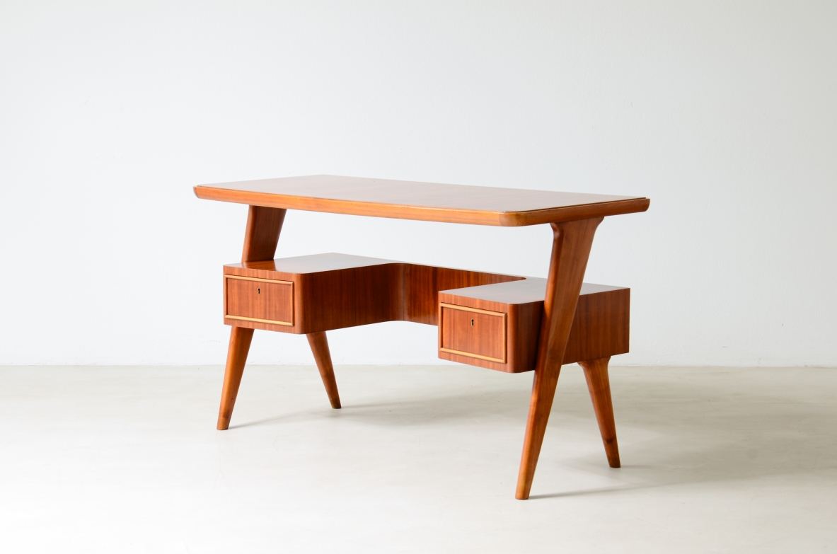 Small walnut desk with two drawers and storage compartment. 1950