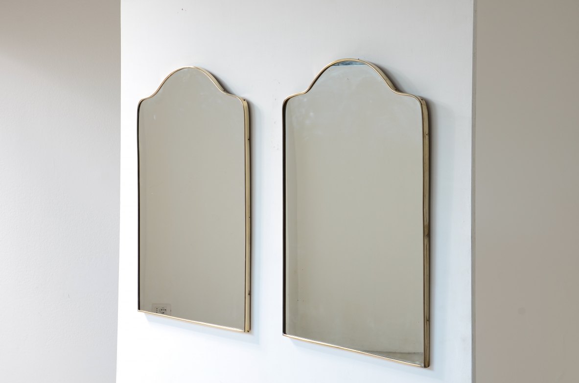 Coppia di specchiere con cornice in ottone sagomato.  Manifattura italiana anni 50ca.